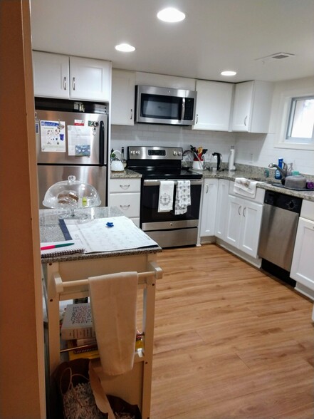 Renovated, full sized kitchen with kitchen cart and stainless steel appliances. - 2509 10th St NE