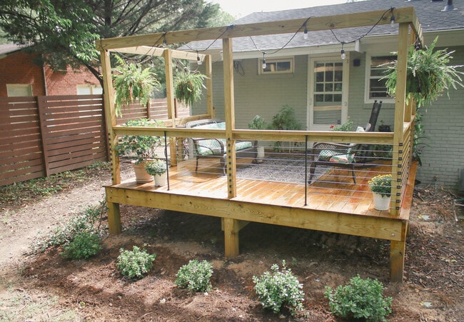 New deck with cable railings offering outdoor entertaining and living space. - 905 Culpepper Ln