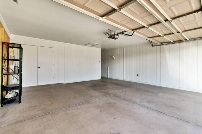 Large 2-car garage with golf cart access to laundry/hobby area. - 12414 W Nugget Ct