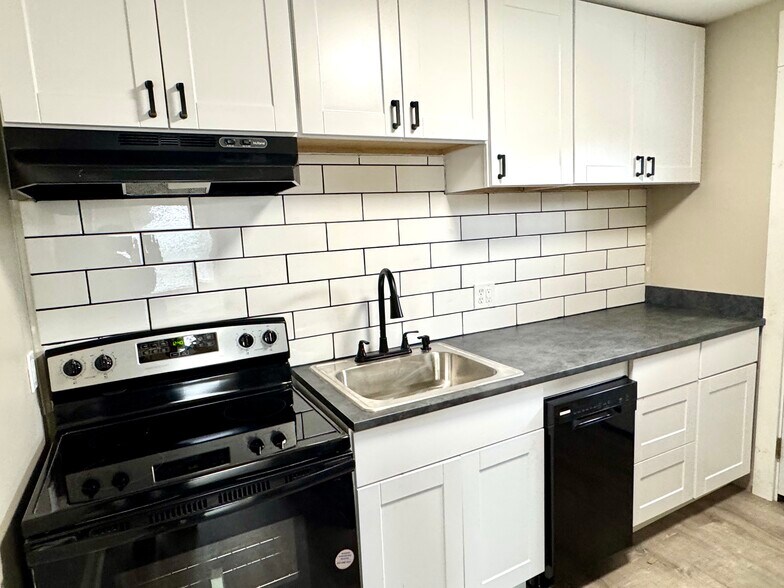 New kitchen with backsplash, stove, refrigerator and dishwasher. - 7100 Thomas Blvd