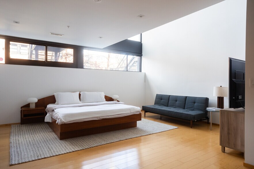 Spacious primary bdrm w/ shades (pictured w/ shades rolled up), king-size bed, R&B daybed & 65" TV - 2250 11th St NW