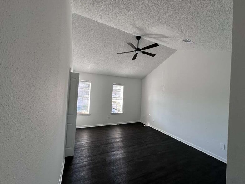 Spacious primary bedroom featuring brand-new ceiling fans, lighting, and double closets. - 7700 Creekbend Dr