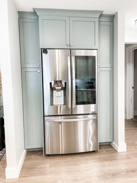 Custom cabinets surrounding full depth refrigerator with built in ice and water in the door. - 303 Woodland Shores Rd
