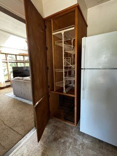 Open storage cabinet next to refrigerator. - 2615 Parker St