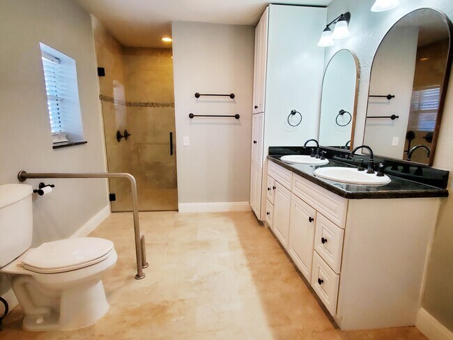 Handicap accessible Primary bath has two vanities, large storage cabinets and a huge walk-in shower. - 37438 Meadowview Dr