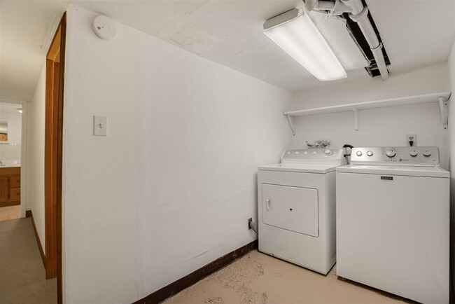 Moving through the basement is the laundry area with full sized washer and dryer. - 2108 E 23rd St