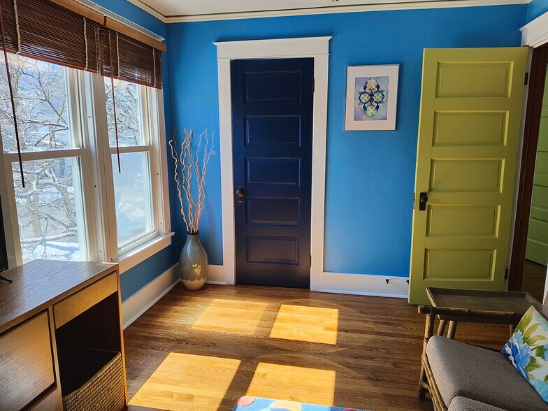 Living Room, windows look into tree top and over garden. - 413 N Geneva St