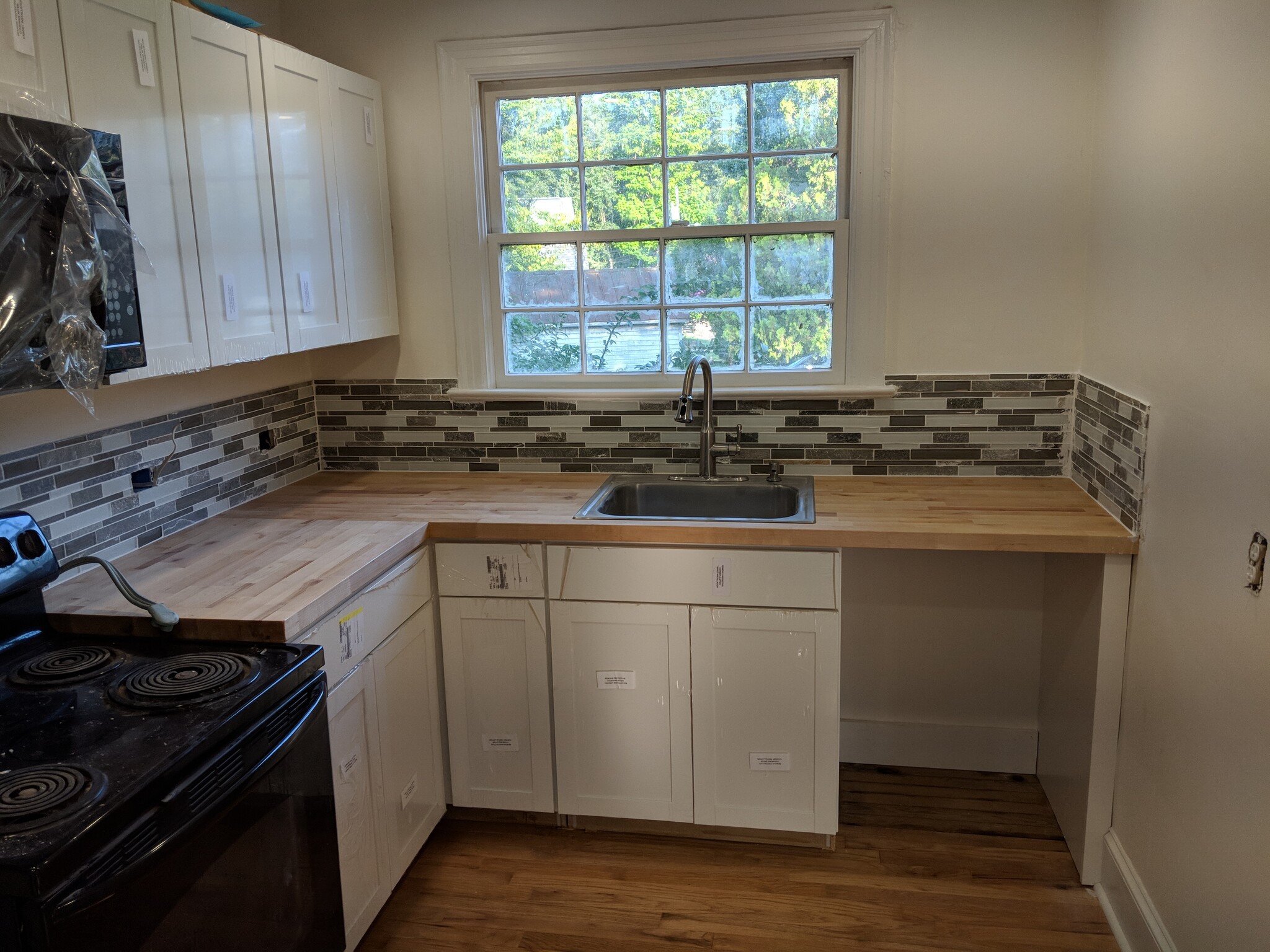 Overlook backyard from the sink. Great natural light in the kitchen. (Dishwasher missing from photo, but will be included) - 1111 Watauga St