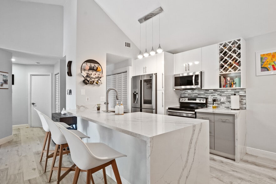 Stunning marble waterfall island kitchen with vaulted ceilings - 15770 SW 104th Ter