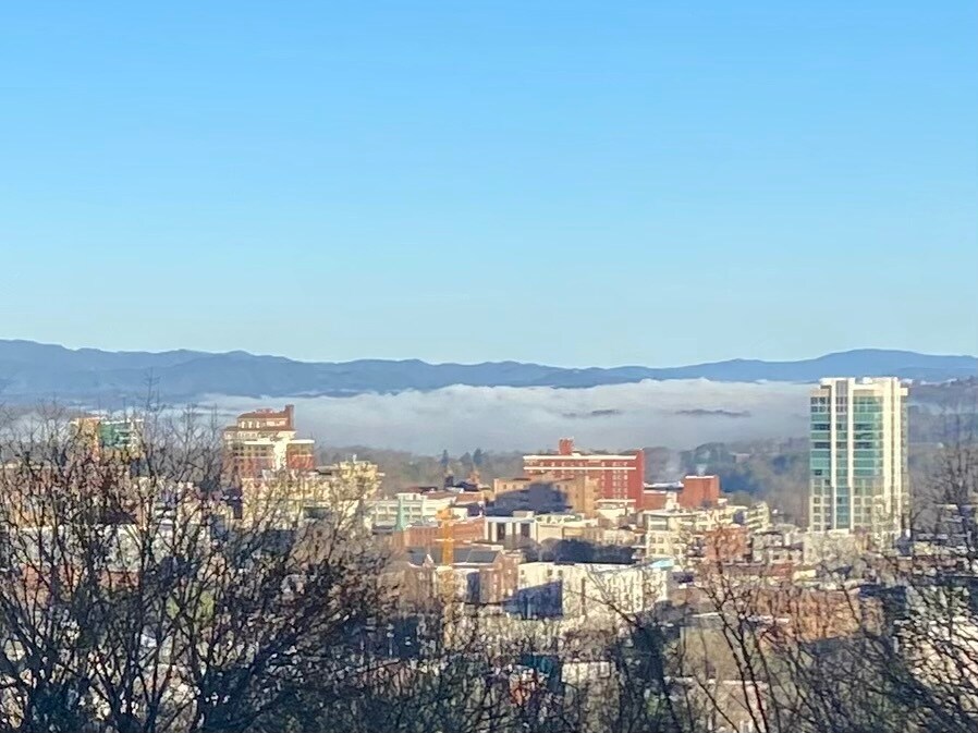 Morning mountain mist rolling over downtown Asheville - a view that changes with the seasons. - 405 Windswept Dr