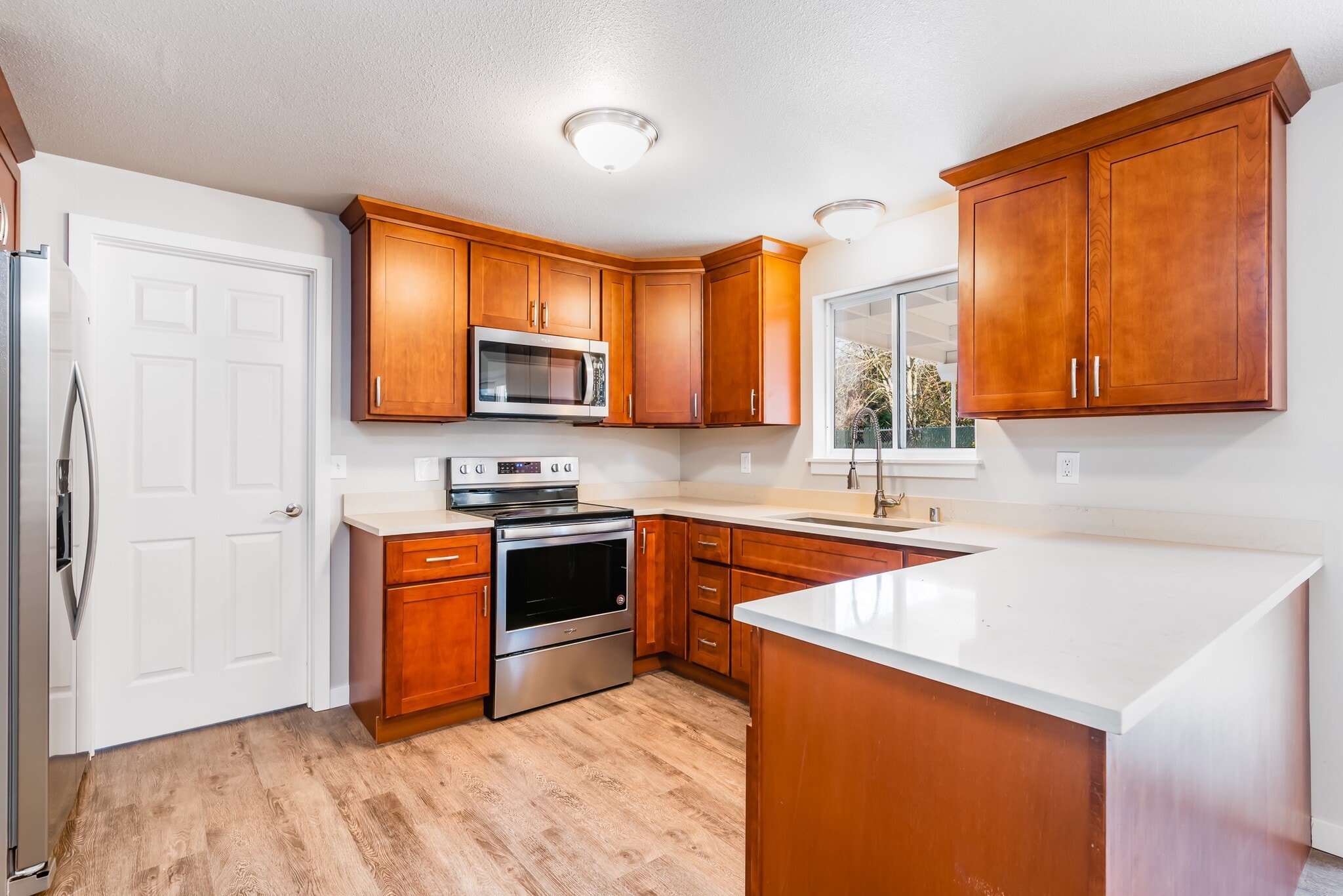 Kitchen with stainless steel appliances and quartz tops - 6235 A St