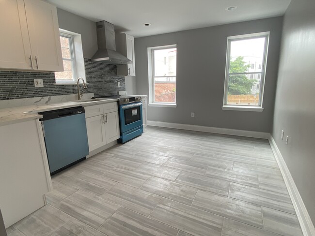 Large sunny modern white kitchen, quartz countertop, porcelain tile floor, stainless steel appliance - 1618 Fitzwater St