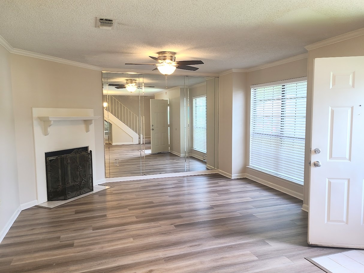 The spacious living room has a wood-burning fireplace and large window for natural light - 12439 Coursey Blvd