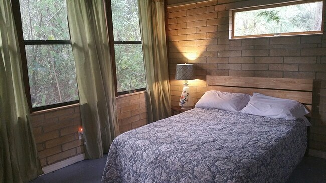Bedroom 2 with large windows overlooking lush backyard - 3812 SW 15th St