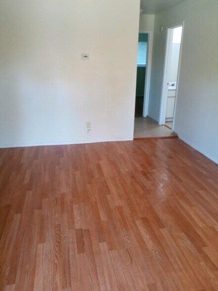 Wood plank and ceramic flooring with hall leading into carpeted bedrooms for quiet and comfort - 120 Lazy Ln