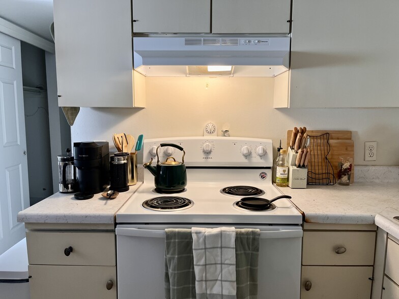 Kitchen view of oven, range, countertops, and sink to the right. - 305 Green Briar St