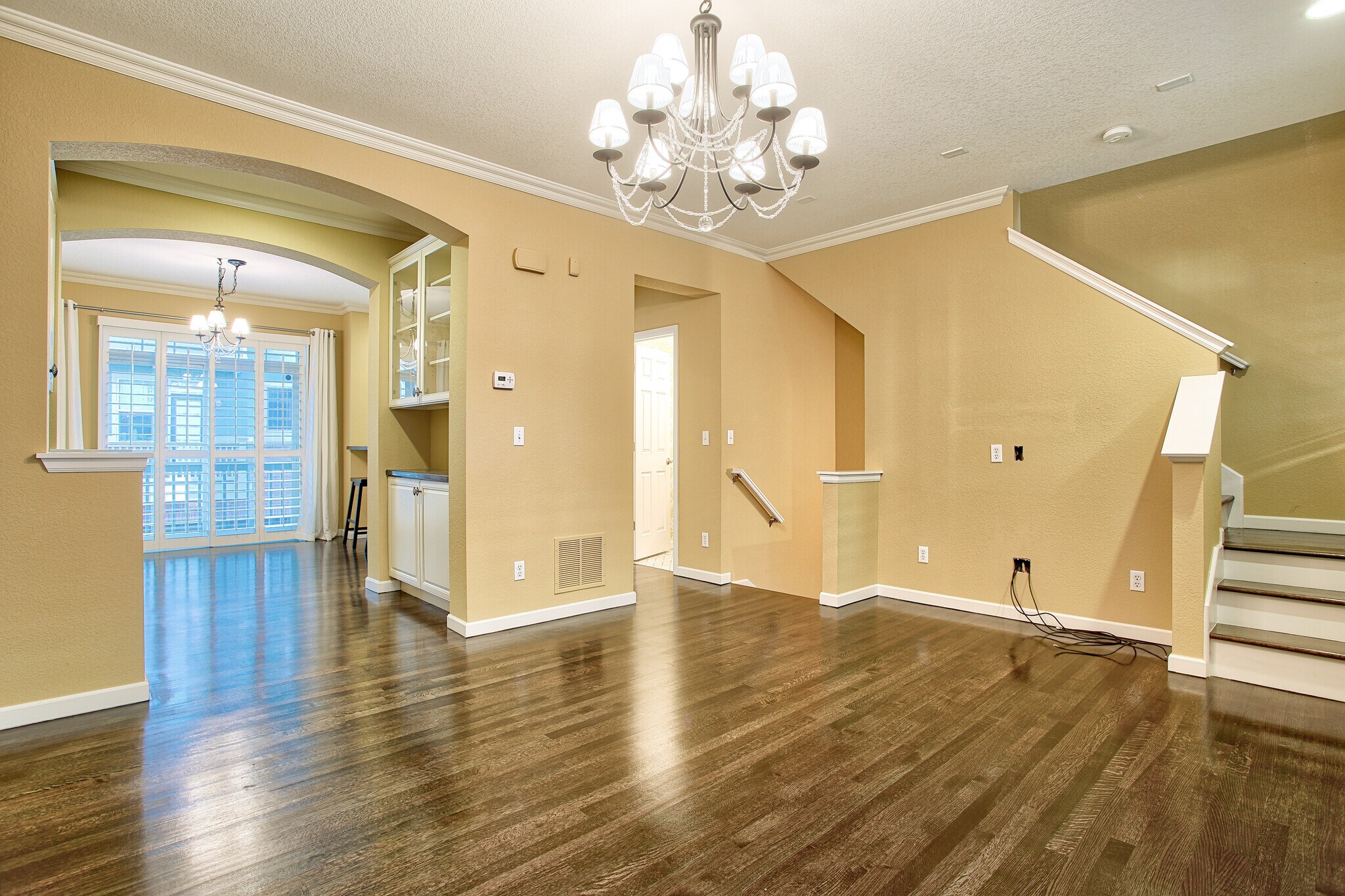 Living room with hardwood floors, plantation shutters, crown molding, chandelier - 7422 E 7th Ave Unit 14