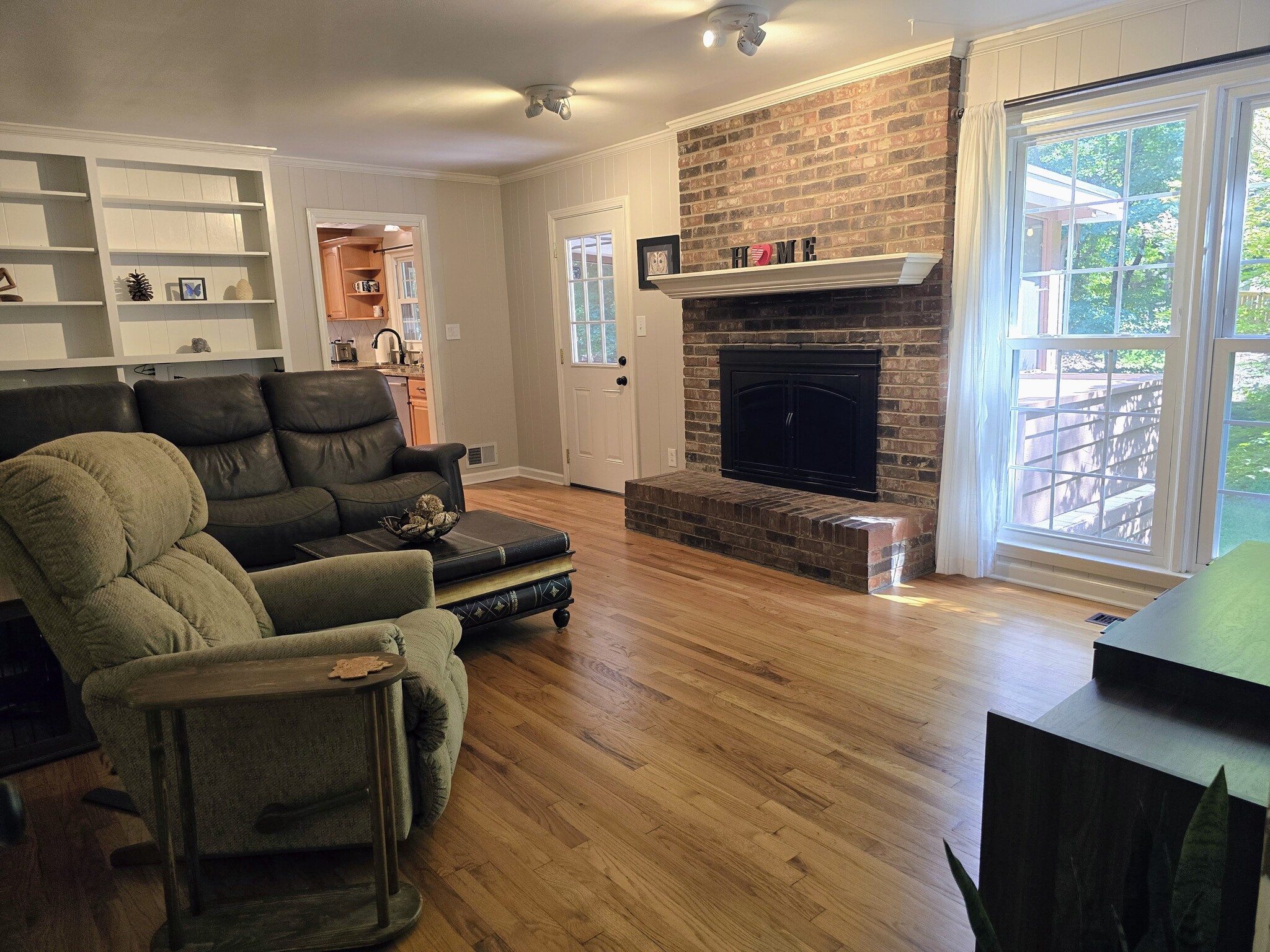 Wood-burning fireplace, built-in bookshelves, and floor-to-ceiling windows - 90 Martin Point Ct