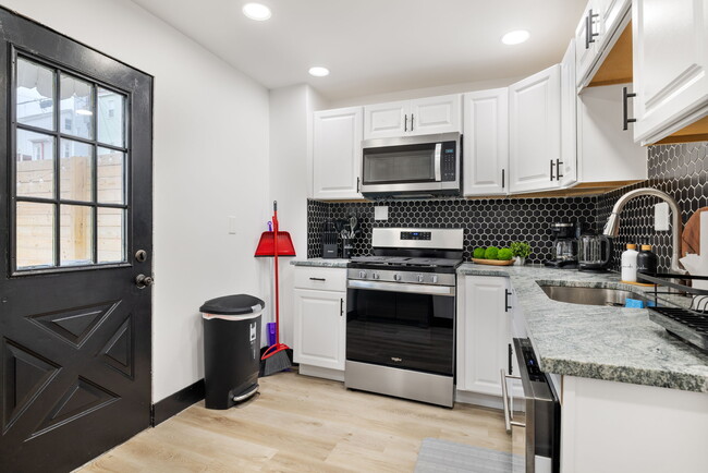 Kitchen with Trash Can, Cleaning Supplies and door to Back Patio - 10 Carrie St