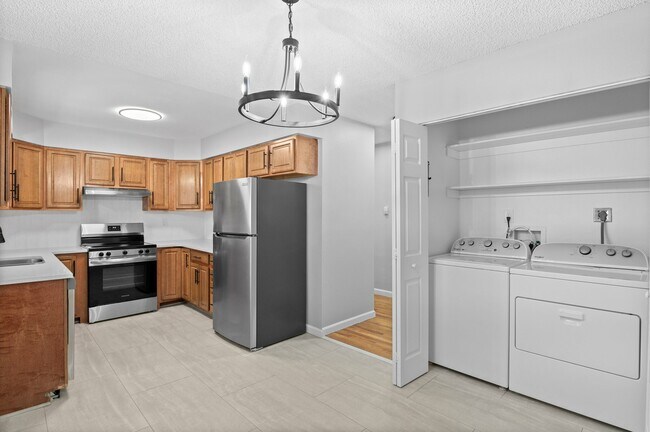 Explore this stylish kitchen and convenient laundry setup, perfect for modern living. - 5580 West 4th Avenue Townhomes