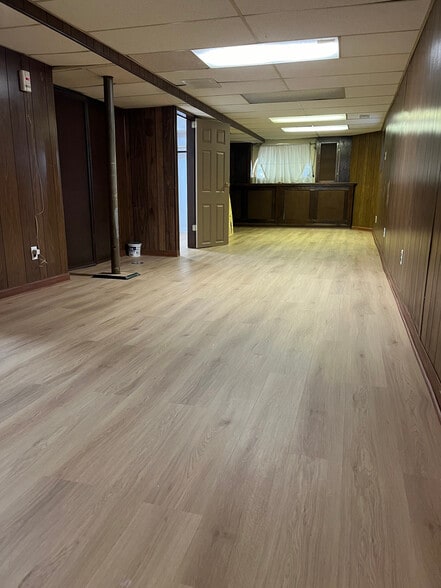 Sala de estar con nuevos pisos por todo el basement. - 5445 N Monitor Ave