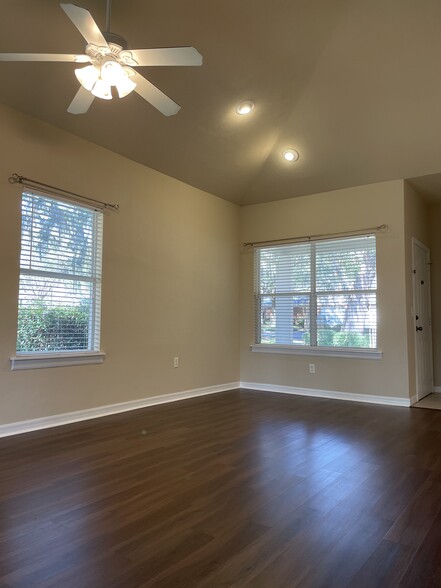 Well lit living room with luxury vinyl plank flooring. - 13200 W Newberry Rd