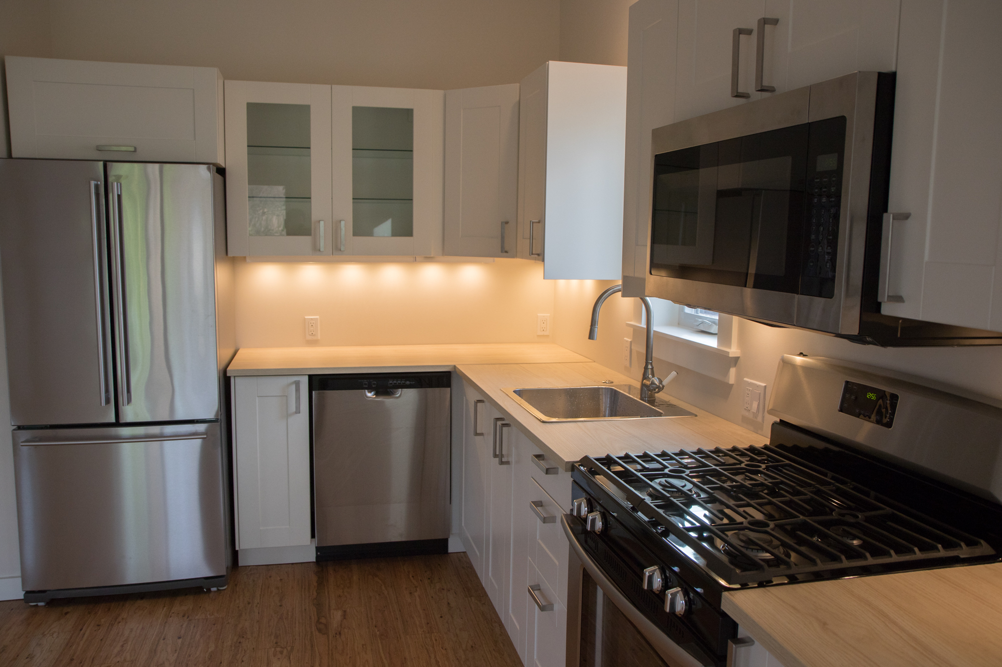 Kitchen details include gas range, microwave, hood, dishwasher, with tile backsplash - 5239 NE Mason St