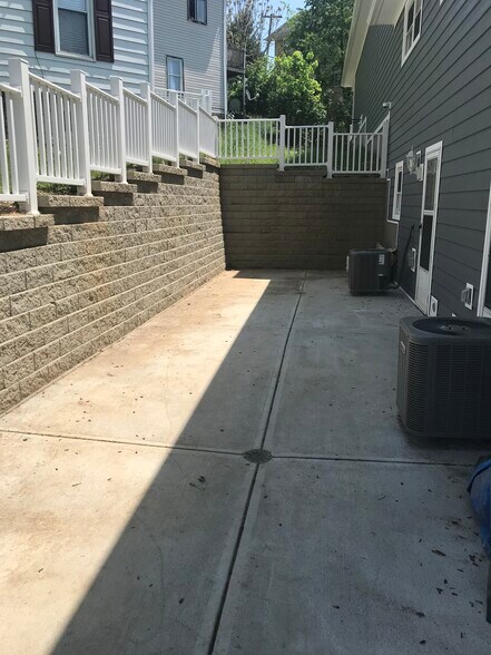 A brand new beautiful retaining wall and fence encloses a shared patio for outdoor relaxation. - 441 West Virginia Ave.