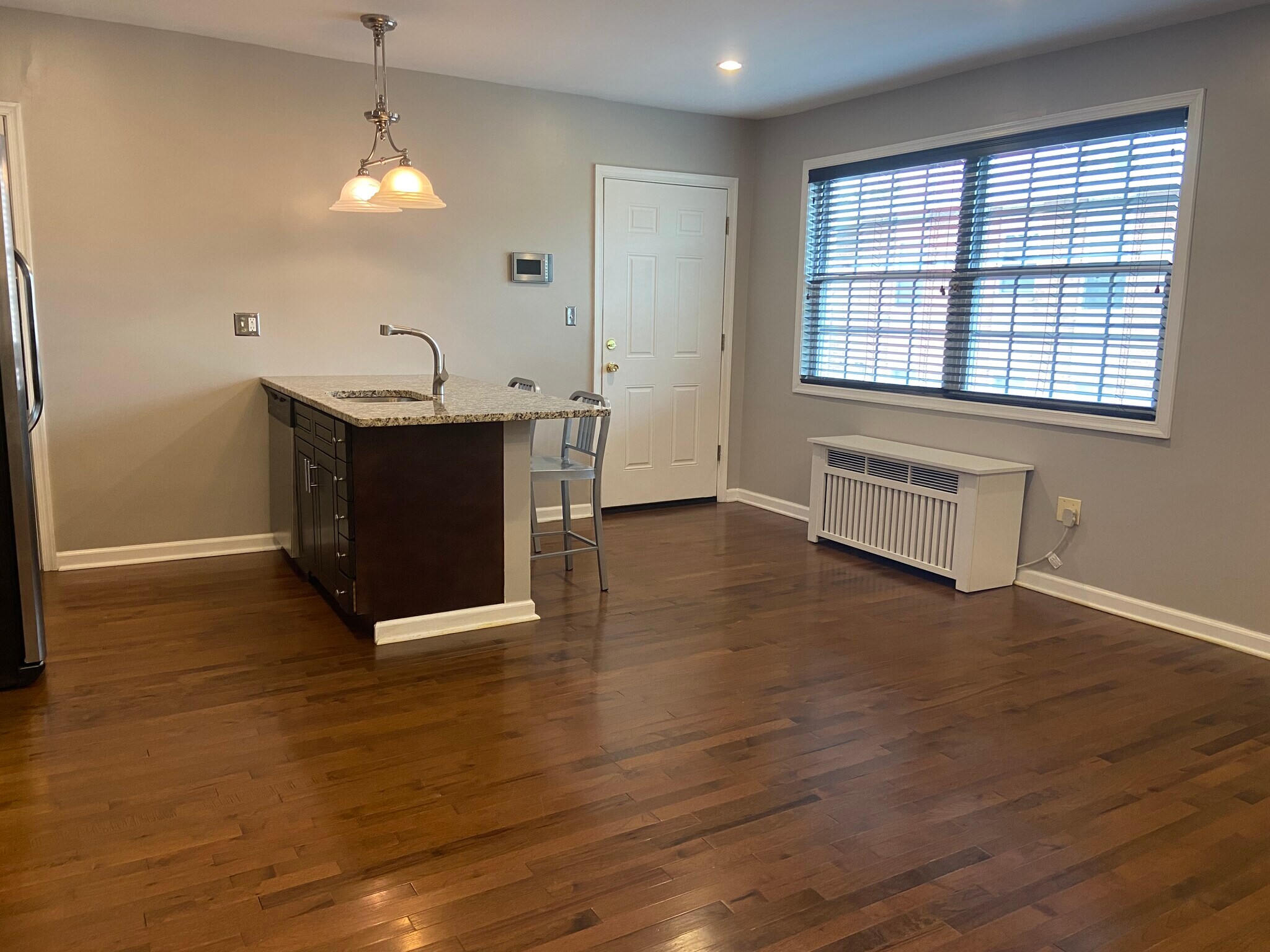 Living room/kitchen/dining with large south-facing windows--perfect natural light on sunny days! - 2576 Sherman Ave NW