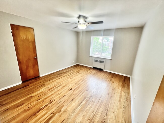 Embrace comfort in this stylish room flooded with natural light and enriched by elegant hardwood flooring. - The Birney Apartments