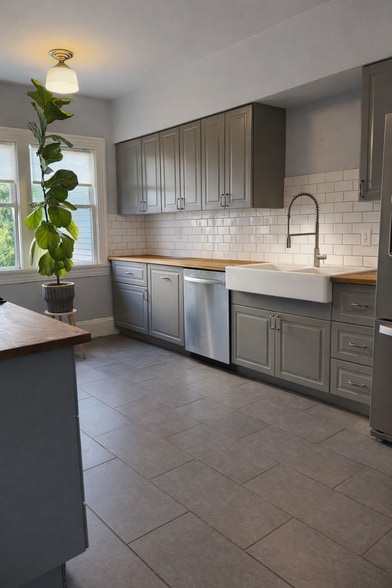 Bright kitchen with, stainless steel appliances, butcher-block counters, and a gas range. - 604 NE Shaver St