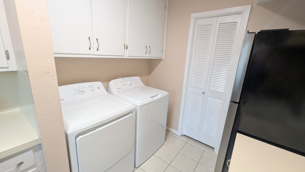 Laundry is a breeze with the new washer and dryer and extra storage cabinets. - 813 Clubside Dr