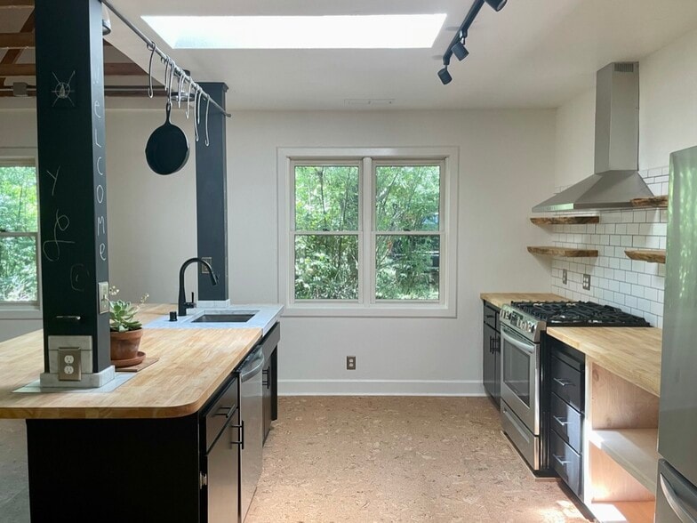 Modern chef's kitchen with butcher block counter tops and lots of natural lighting. - 6605 Shady Lake Ln