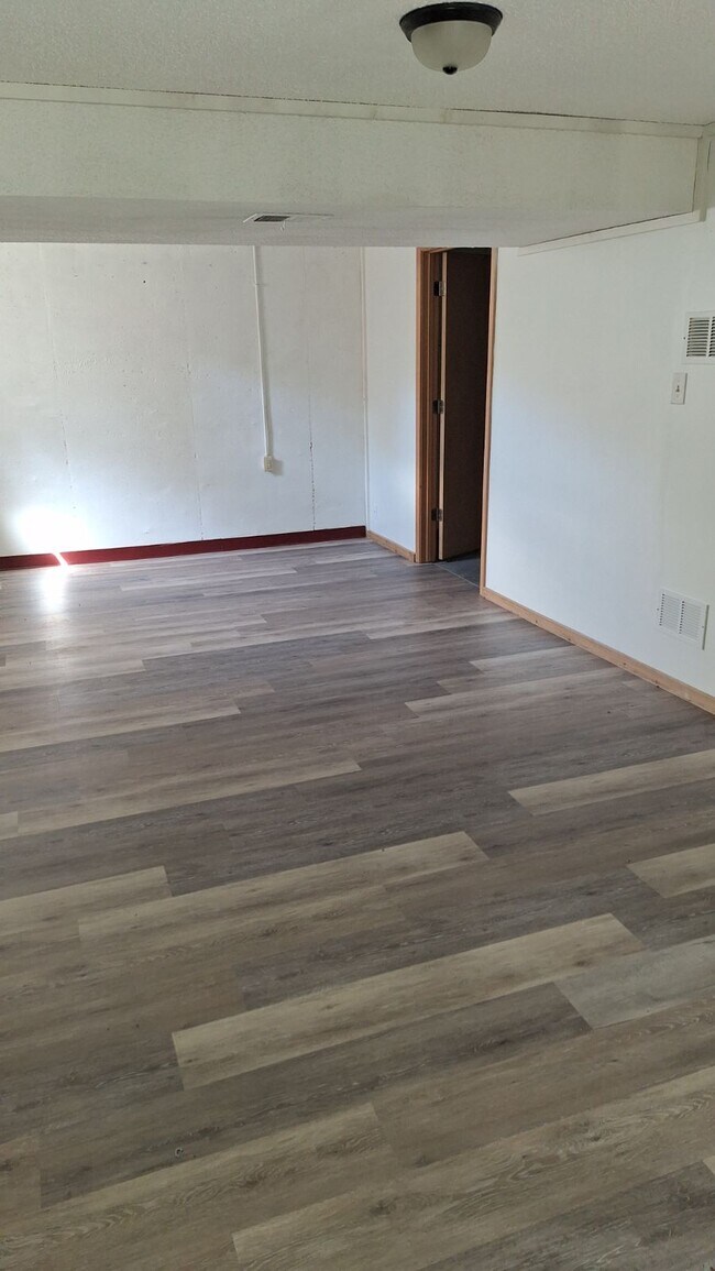 Beautiful new flooring in basement. Door leading to storage and laundry area - 5341 SW 15th Ct