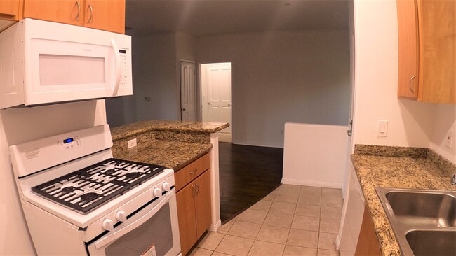 The kitchen includes a stove, oven, microwave, dishwasher, and garbage disposal! - Haleakala Luxury Apartments