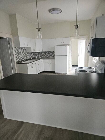 Tiled backsplash that accents the refurbished 1950s vintage metal cabinets. Refrigerator present and - 728 S 15th St