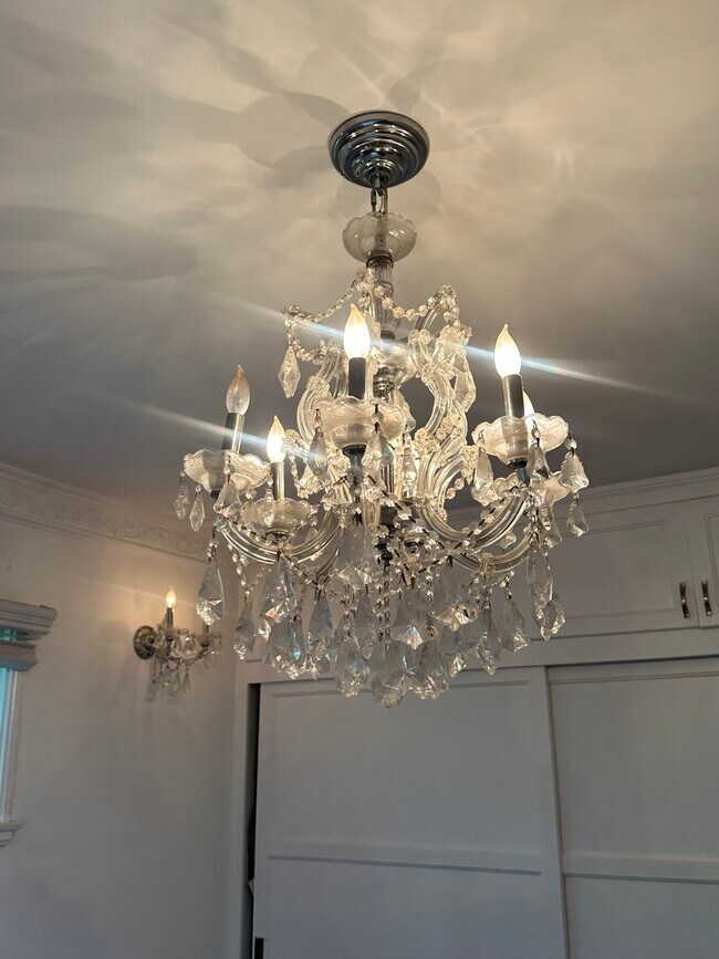 Elegant and romantic crystal chandelier graces the bedroom. - 1857 Pandora Ave