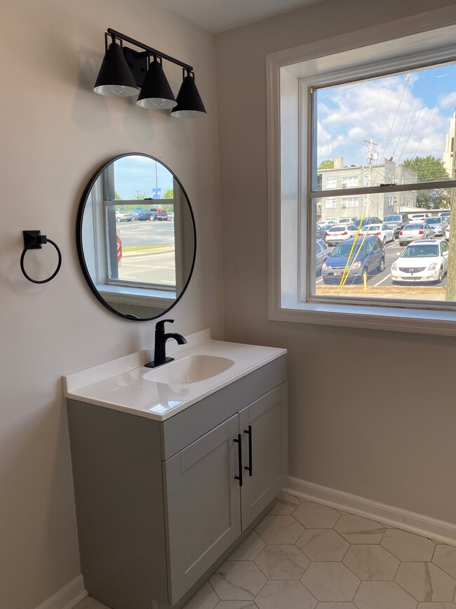 Updated bathroom fixtures and cabinetry - 8th Street Apartments