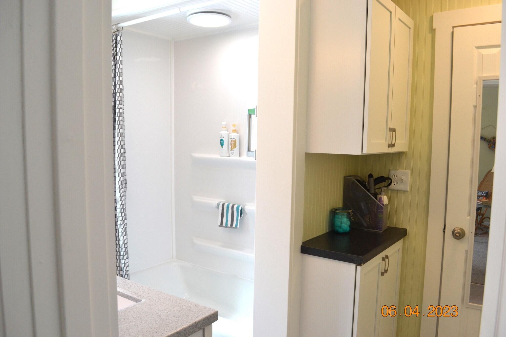 downstairs full bath has tub/shower combo and linen cabinets with "grooming counter" - 222 W Peck St