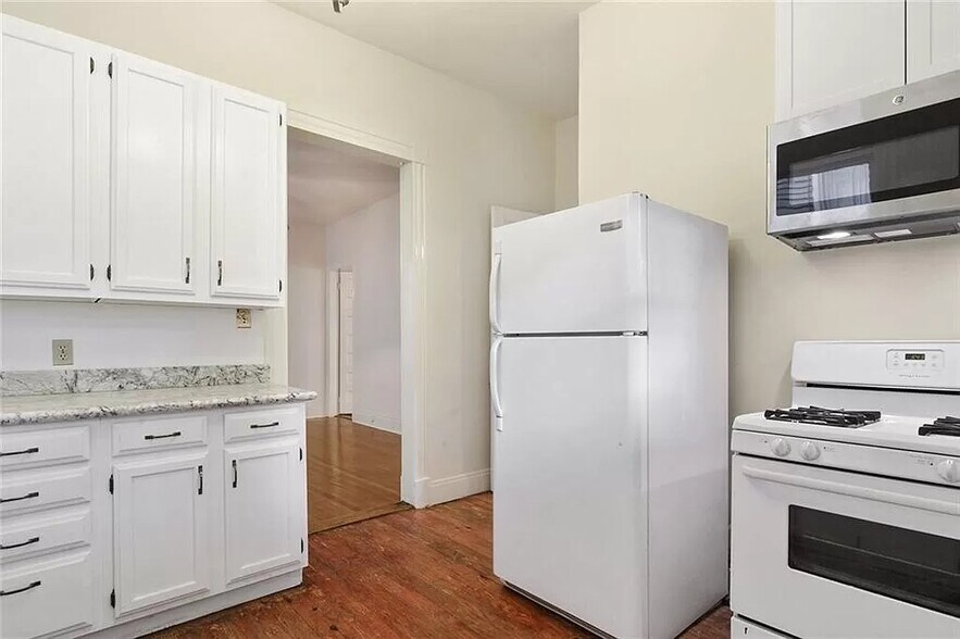 KITCHEN AT THE REAR OF THE APARTMENT HAS 4 BURNER GAS STOVE WITH MICROWAVE, WHITE CABINETS, DISHWASH - 8 Neron Pl