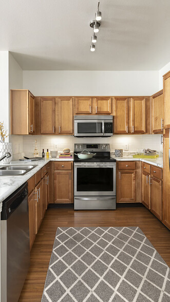 Apartment Kitchen with Stainless Steel Appliances, quartz counters and wood floors. - Griffis Fitzsimons South