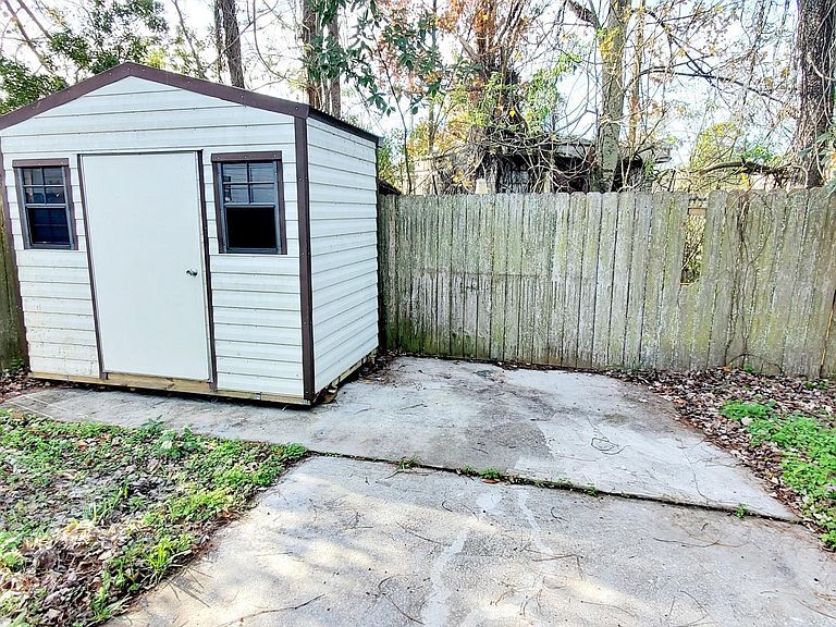 Private backyard concrete patio with fenced yard and extra storage shed. - 1300 Bay Hill Blvd.