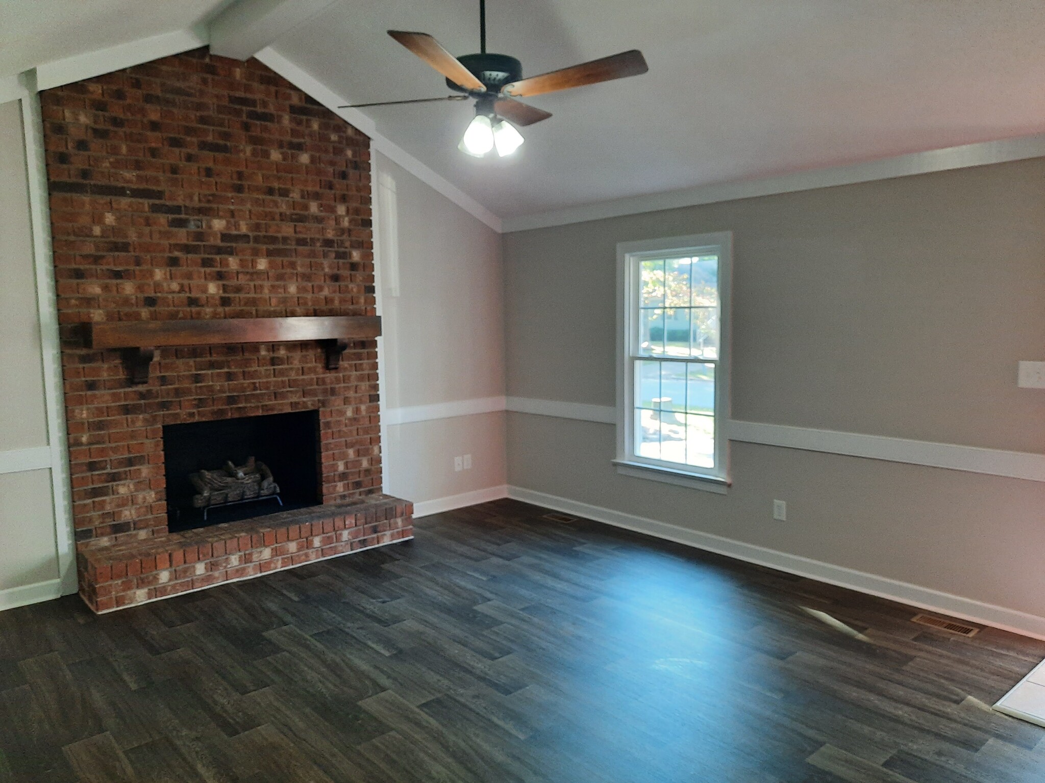 Spacious living room with vaulted ceiling and brick fireplace - 1717 Old Barn Rd