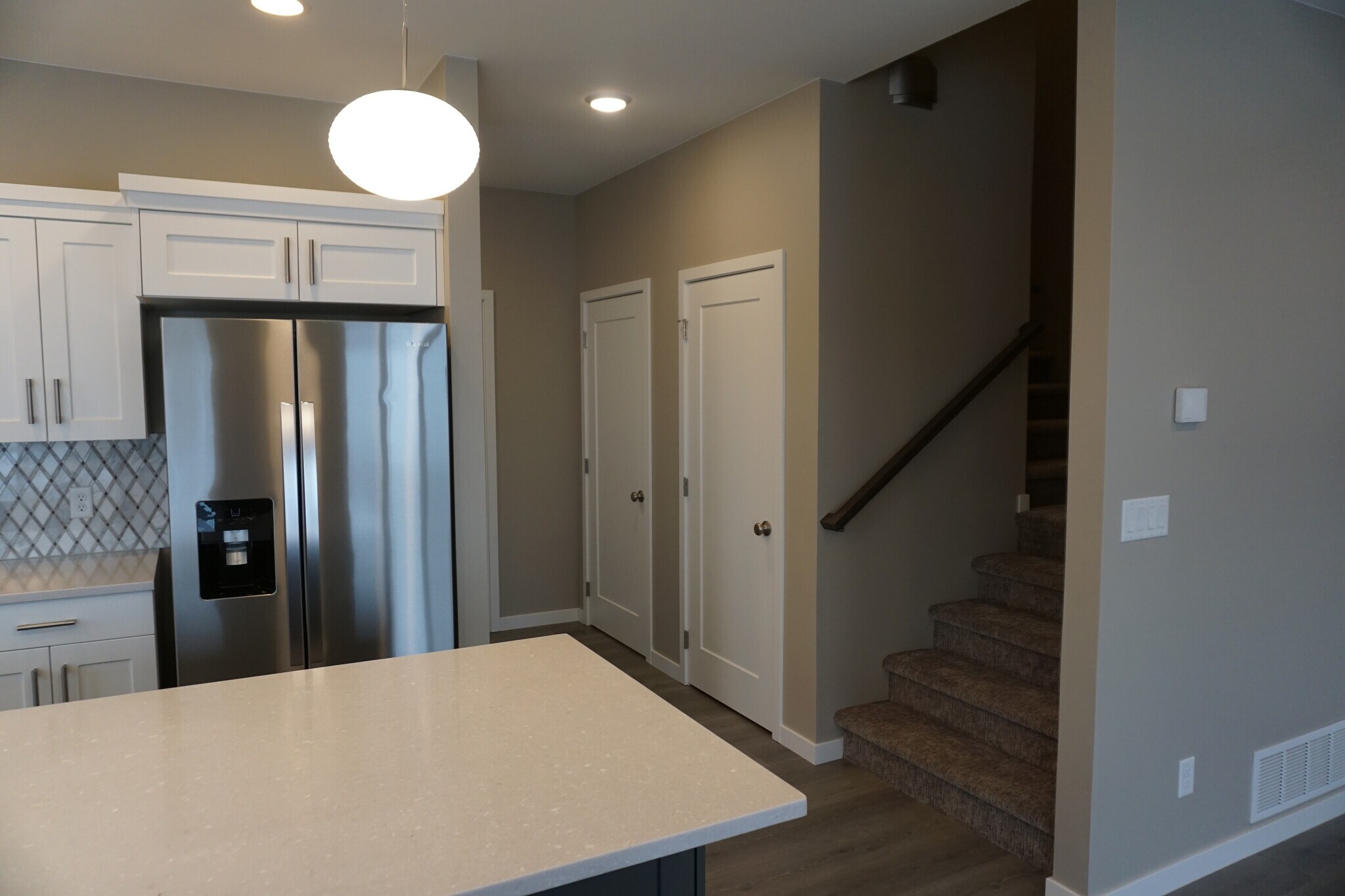 Looking toward the pantry door, storage space and stairs to upper level (Photos are of similar unit with similar finishes.) - 3811 Stacy Drive