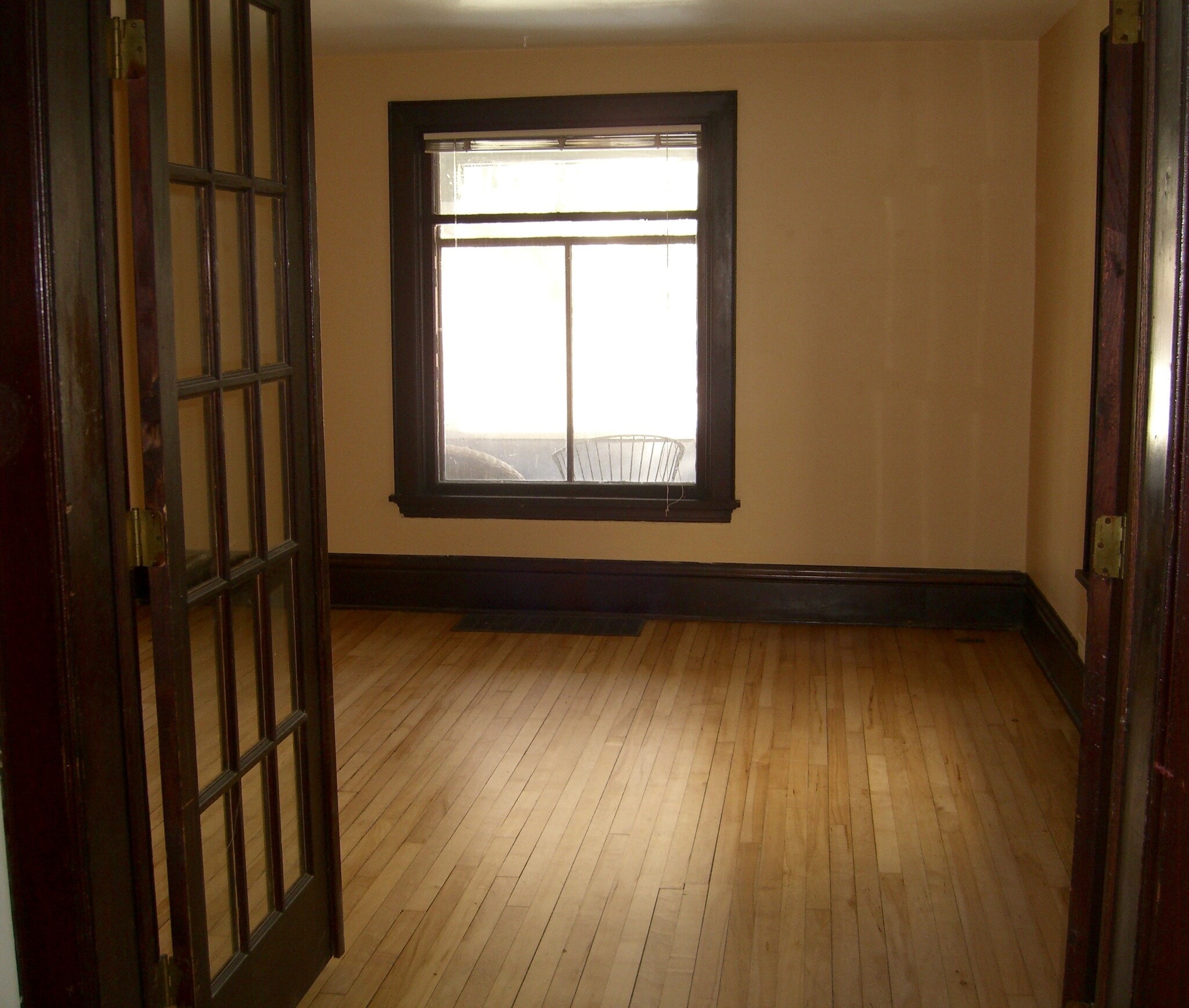 Living room with pleasant natural light and French doors into dining room - 945 E Johnson St