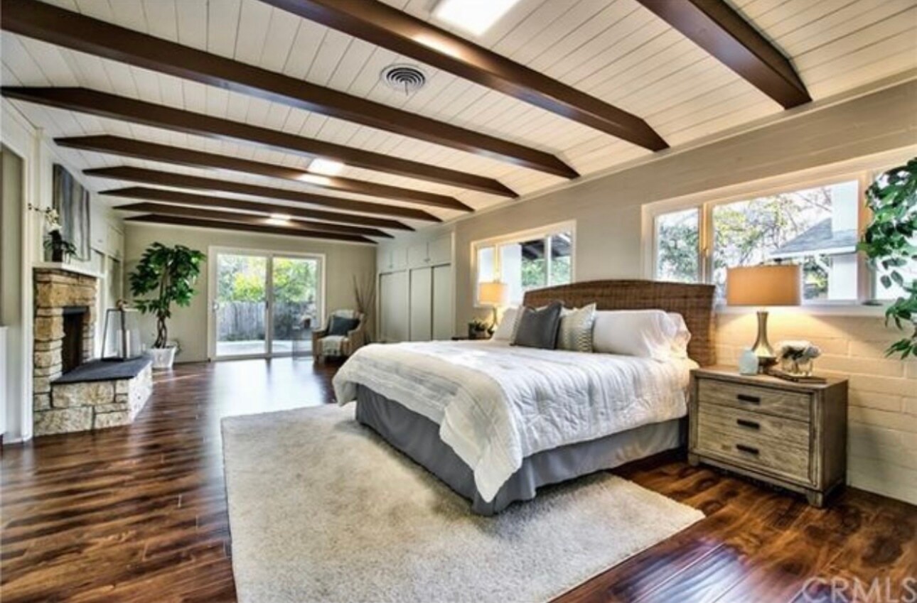 Spacious master with beamed ceilings, fireplace, wall of windows, patio access & 3 closets. - 332 E Deodar St