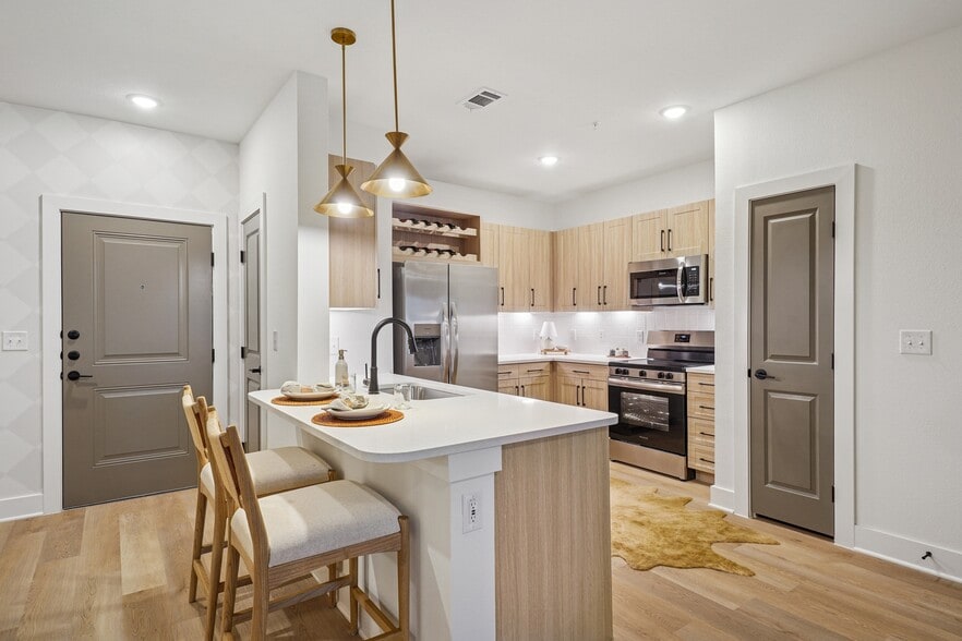 Kitchen with Quartz Countertop and Stainless Steel Appliances - The Sylvan at Painted Tree