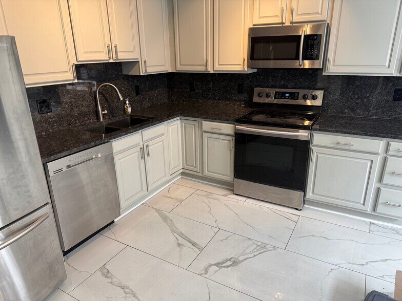 Kitchen with granite counters and backsplash - 2675 S University Blvd