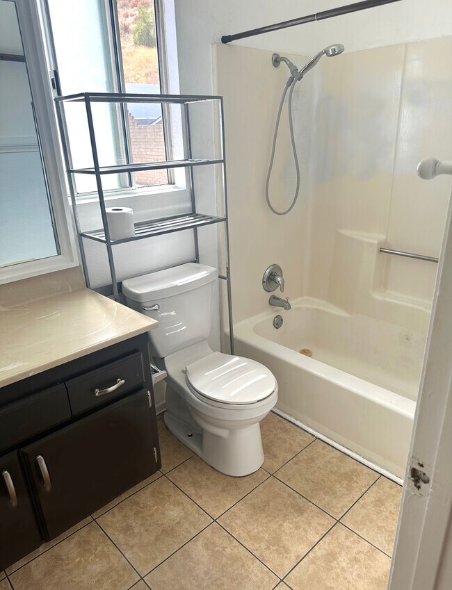 Spacious bathroom with tube and window - 240 E Graham Ave