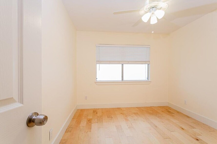 Guest bedroom is furnished with a simple, iron bed frame and queen mattress (not pictured). - 909 Reinli St